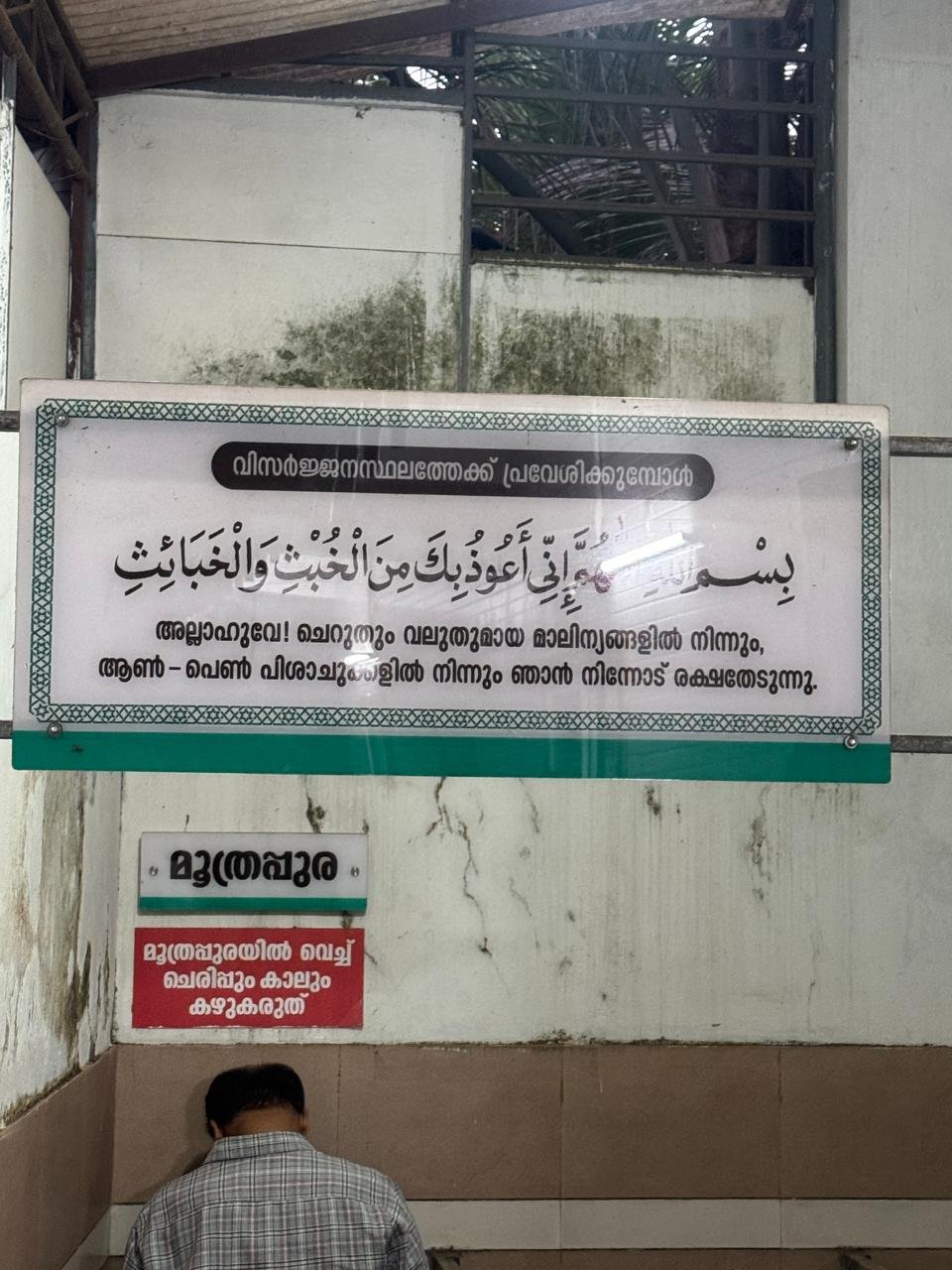 Du‘a board installed inside a toilet area