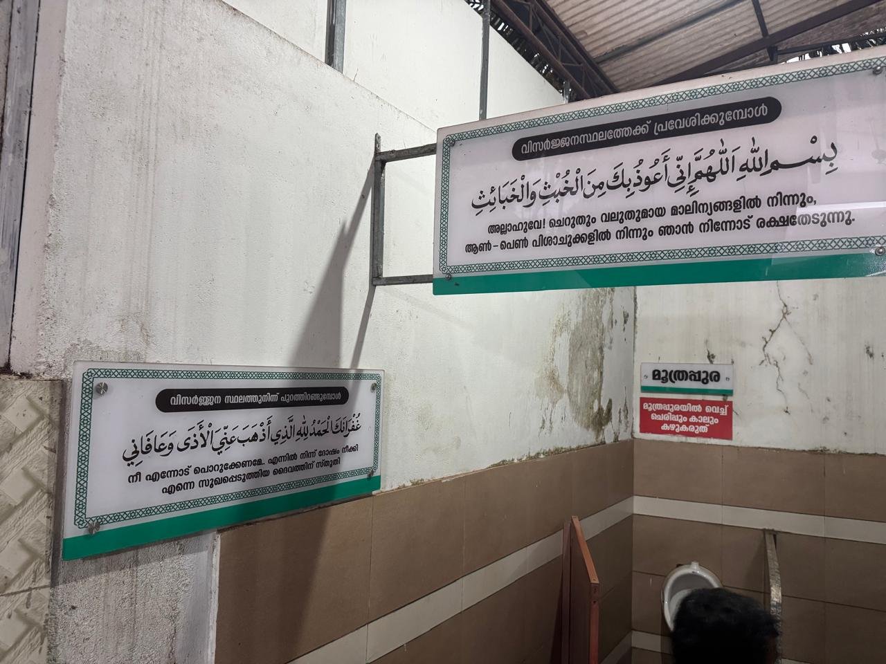 Two religious-text boards inside a toilet area